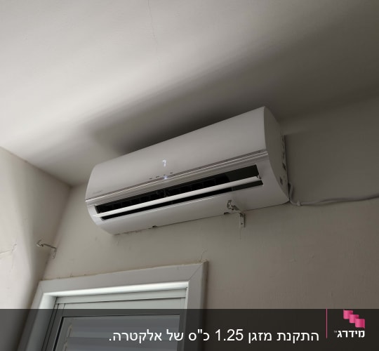 מזגן מותקן על קיר מעל חלון עם תריסים